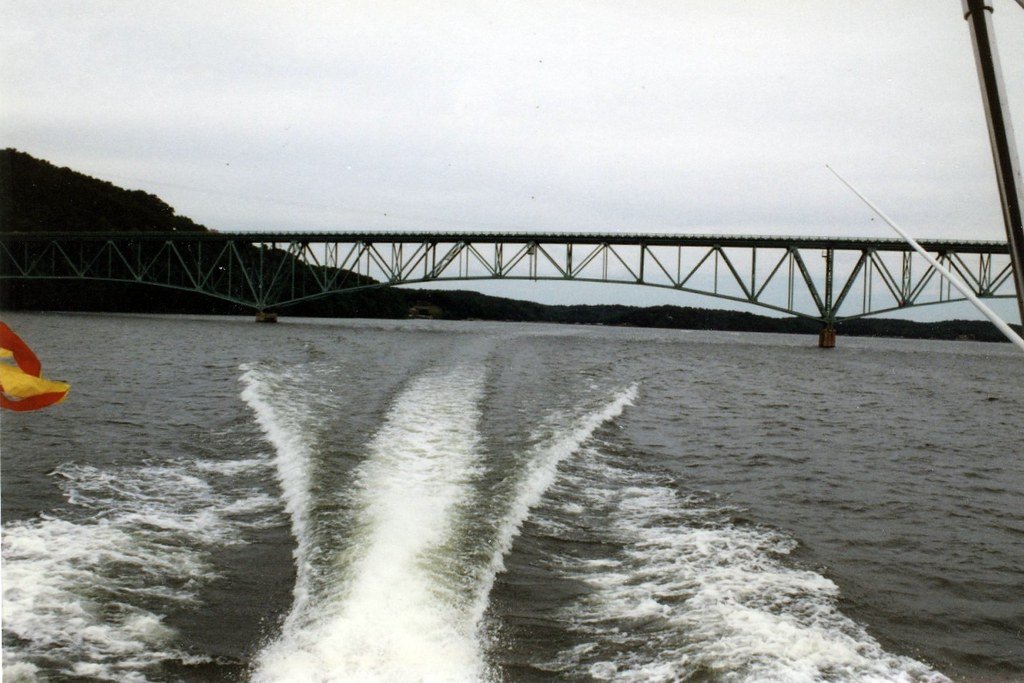 Boat wake on Lake of the Ozarks with the Grand Glaize bridge behind